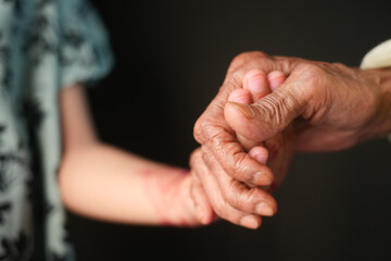 little girl holding hand of her grandmother hand 