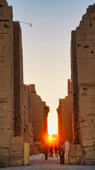 Morning sunlight fills the central passage of the Great Temple of Karnak illuminating majestic...