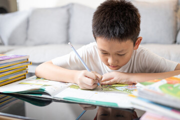 Child boy concentrate and focusing on studying,doing homework,writing,reading book,concentration in work,after treatment of disease,heal a disorder,concept of Attention Deficit Hyperactivity Disorder
