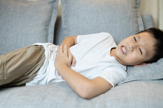 Sick child boy has a stomach ache,abdomen pain from enteritis,food poisoning,illness caused by bacteria or other toxins in food,upset stomach,inflammation,infection of the intestine,Diarrhea,Dysentery