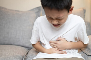 Child boy holding his stomach,kid suffering from stomachache,abdominal disease,pain ache in belly,Problem with intestine,distended belly,bloated stomach,digestive disorders or Irritable bowel syndrome