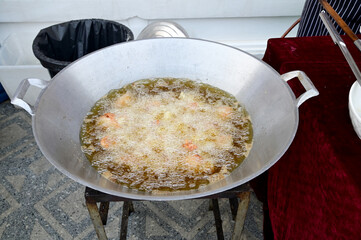 Closeup of Chicken fried in a pan with hot oil on a gas stove at street food of Thailand.