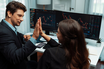 Successful in two business traders making hands high five with fist up to earn highest profit stock...