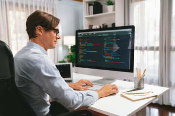 IT developer working online software development information on pc and laptop screen with typing to...