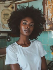 A young woman with curly hair is looking at the camera. She is wearing a white shirt and has a serious expression on her face.