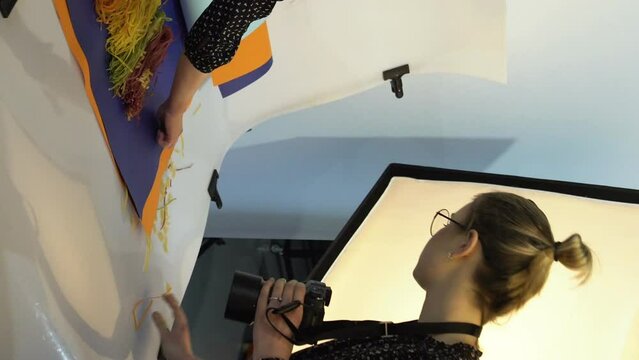 Vertical video. Food backstage. Photography art. Stylist and photographer women communication teamwork brainstorming for creation photoshoot in studio.