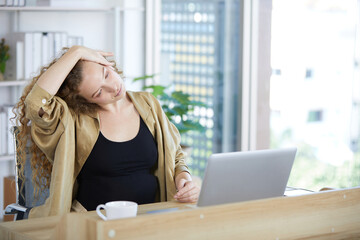 businesswoman doing exercise and stretches neck after finishing work in the office