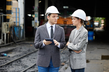 businesspeople talking and checking train on construction site