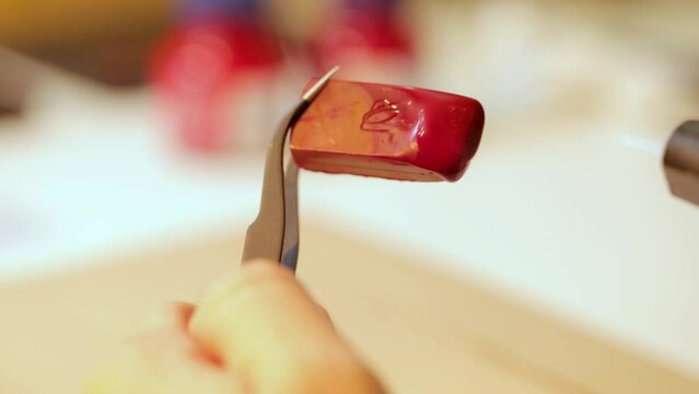 Lacre de cera quente pingando em papel pardo. Carimbo antigo de metal e madeira sendo prensado no papel do envelope.