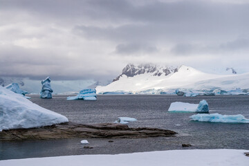 Giant iceberg and intriguinly shaped ice formation align the Coast of Charlotte Bay, as seen from Portal point.