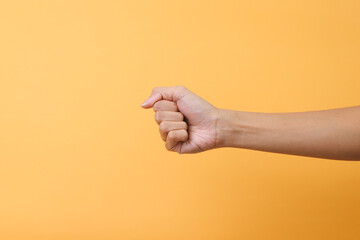 Hand showing fist isolated on pink background