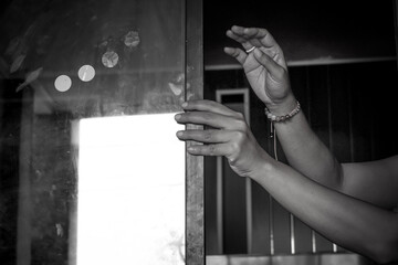 a pair of women's hands opening the window