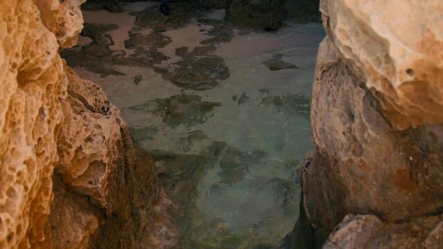 Cleopatra Beach Marsa Matrouh Egypt, tourist standing in small bay between rocks at sunset