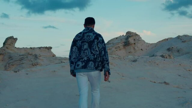 Tourist walking alone on sand dunes in Cleopatra Beach lagoon in Marsa Matrouh, Egypt.