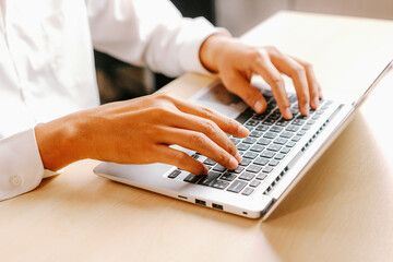 Businessman hand typing on computer keyboard of a laptop computer in office. Business and finance...