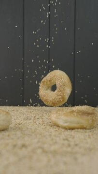 Seasoning bagels with sesame seeds dropping