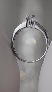 Wedding ring on woman's white shoes. Beautiful wedding ring on the bride's women sandals, wedding engagement. Close up shot with backlight sparkles. Vertical video