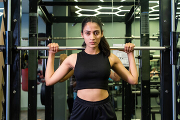 Fitness indian woman lifting t barbell in gym. sports Exercise, Workout, Weight Training, build...