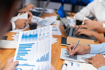 Diverse group of business analyst team analyzing financial data report paper on office table. Chart...