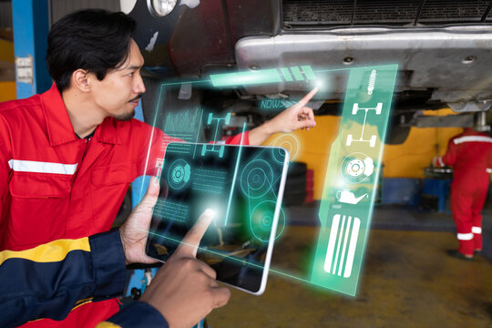 Car mechanic inspects car using technology and computer show resault at virtual screen.