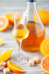 Homemade orange infused vodka, tincture or liqueur of citrus on light background. Fruit alcoholic drinks concept.