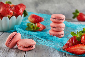 Fresh strawberries and macarons atop a blue tablecloth