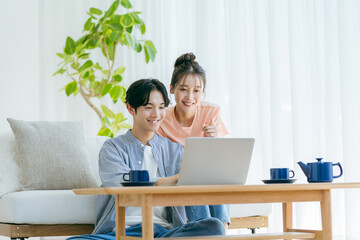 パソコンを見る若いカップル