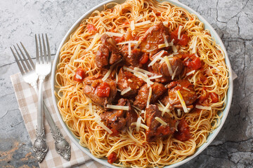 Kokkinisto is s simple beef stew with tomatoes and red wine with pasta spaghetti closeup on the...