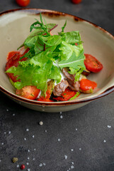 Warm salad with beef tender sauce and cherry tomatoes