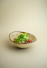 hot salad with beef, mushrooms and cherry tomatoes on the background