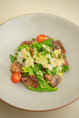 hot salad with beef, mushrooms and cherry tomatoes on the background