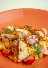 pasta with chicken in creamy sauce and cherry tomatoes