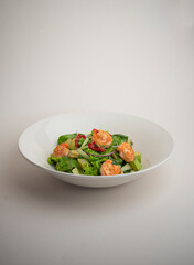 green salad with shrimp and chili pepper on a gray background