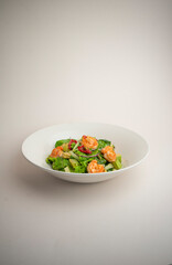 green salad with shrimp and chili pepper on a gray background