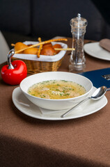 chicken soup with a basket of bread in a restaurant