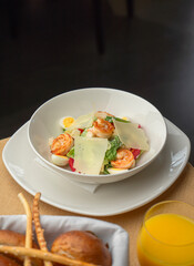 Caesar salad with shrimp and Parmesan in a cozy restaurant