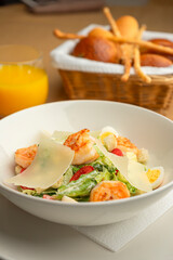 Caesar salad with shrimp and Parmesan in a cozy restaurant