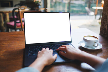 Mockup image of a woman working and typing on laptop computer with blank white desktop screen