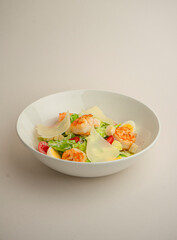 Caesar with shrimp and parmesan on a gray background