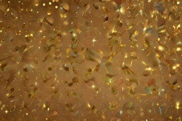 Abstract glittering gold background with shiny glossy sparkles. Gold particles and sequins and light bokeh