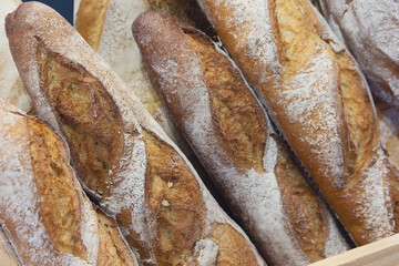 Fresh backed crisp baguettes on the bakery counter close up