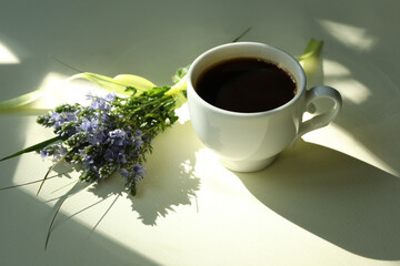 Cup of hot black coffee. Morning coffee with flowers. Romantic morning
