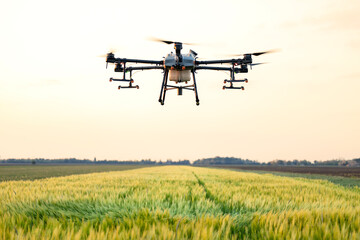 Agriculture drone in action flying over crops field.
