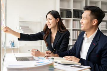 Asian business men and women work together to analyze business finances, present and explain and use laptops and tablets. teamwork Financial marketing team