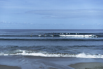 Many surfers catch waves in the ocean, Bali