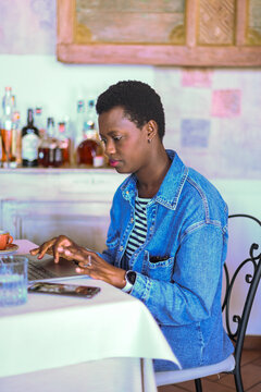 Focused african freelancer use laptop at  cafe setting remote working