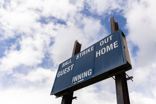 Baseball scoreboard against puffy clouds