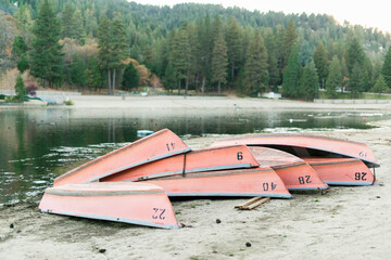 Capsized rowboats on shore, autumn serenity prevails