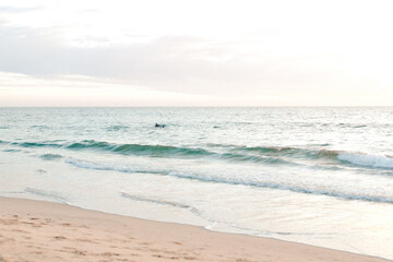 Serene beach at dusk with soft waves and pastel sky