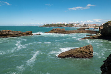Panorama costeiro: Rochedos na Praia de Biarritz com parte da cidade ao fundo em França - obrazy, fototapety, plakaty